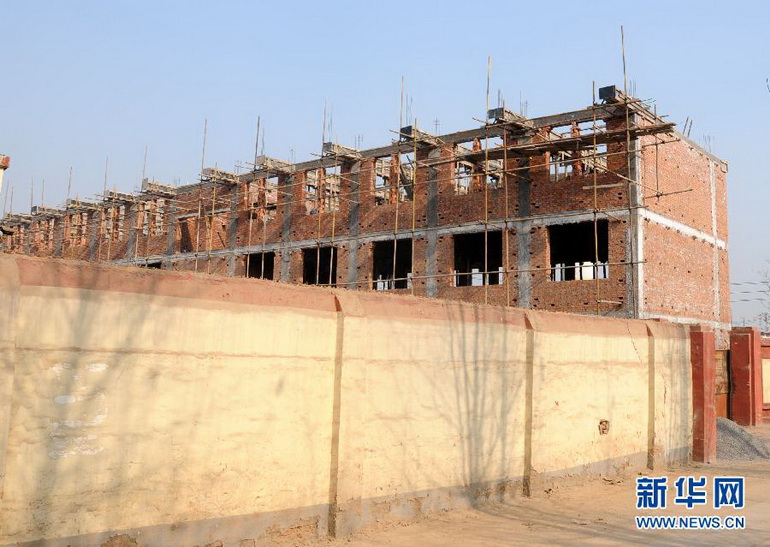 小司空村东头,一排8套的3层连体“别墅”已经建到了第6排(1月9日摄)。一排8套的3层连体“别墅”已经建到了第6排,有的大门上贴着喜庆的大红对联。由建设工地前行不过百米,就到了洹河岸边,隔河相望,就是殷墟宫殿宗庙遗址区。这个“农民别墅群”坐落在河南安阳殷墟核心地带的小司空村,如今,私搭乱建已呈蔓延之势,殷墟正遭受有史以来最大规模的破坏。新华社记者桂娟摄