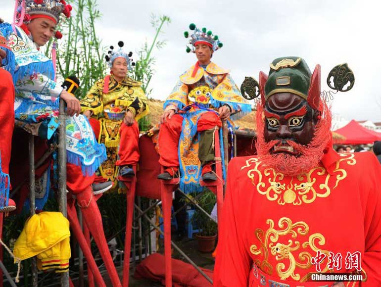 3月25日,演员在后台等待上演非物质文化遗产傩舞与"高跷马"的民俗节目