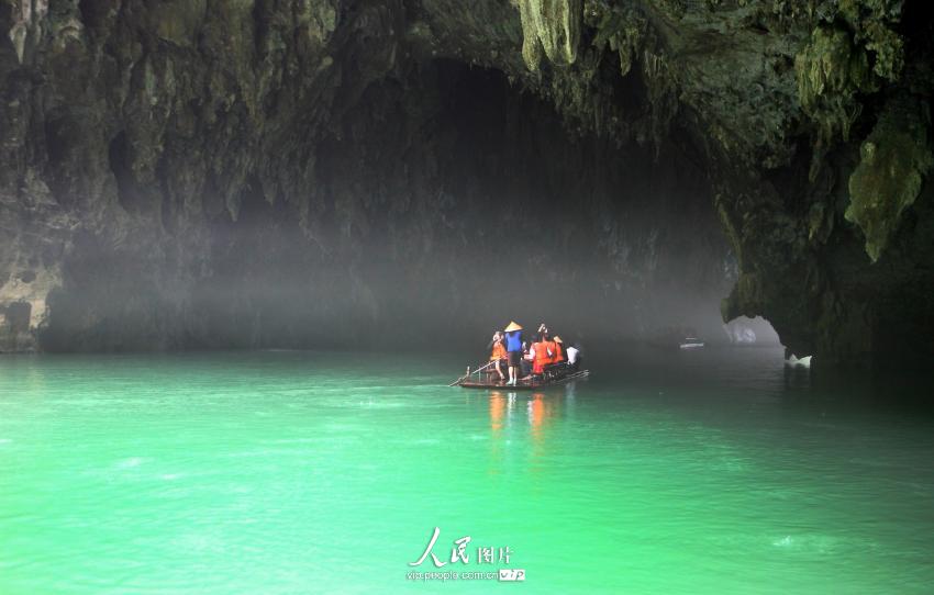 5月19日,广西凤山世界地质公园三门海景区一条游船在地下河缥缈的雾层