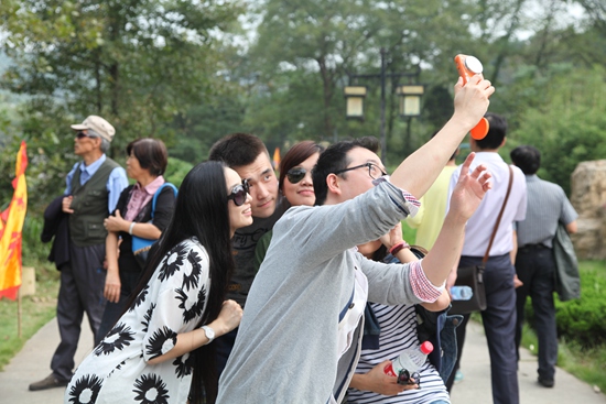 一群年轻人在天下第一福鼎前玩自拍