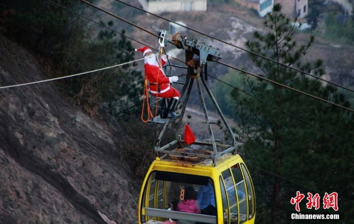 高清：湖南一景区“圣诞老人”爬高空索道为游客送礼【2】