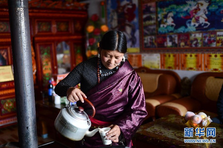 9月11日，在河源新村，一位藏族妇女在家中为客人倒奶茶。