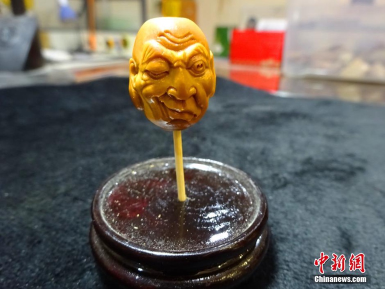 高清：郑州核雕艺人橄榄核上展现“双面十八罗汉”