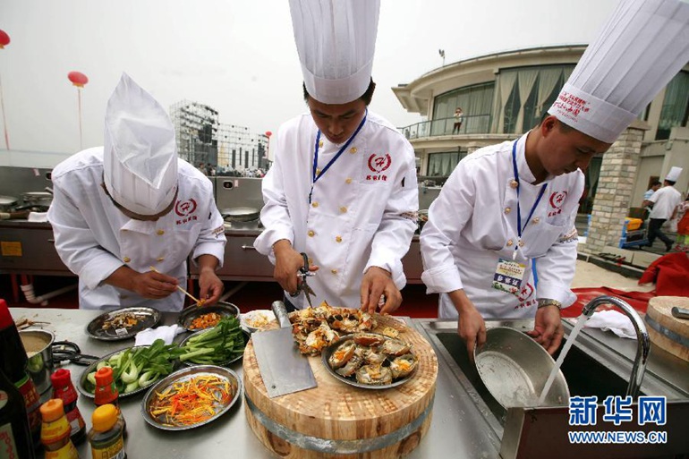 2015年9月19日，在第15届中国高淳固城湖螃蟹节上，厨师现场制作螃蟹菜肴。来自全国各地的40多名厨师从6时许至16时，先后分4场，共制作出108道全蟹宴。经上海大世界基尼斯总部工作人员统计核实，创造了“最多不重样的螃蟹菜肴纪录”。新华社发（王新摄）