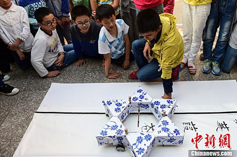 10月15日，学生们观看会写中国书法的机器人。中新社记者 韩苏原 摄