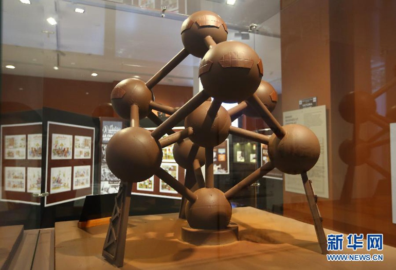  这是10月21日在比利时布鲁塞尔巧克力村拍摄的微缩巧克力版原子球。原子球建造于1958年的布鲁塞尔世博会，高102米，总重2200吨，由9个直径18米的空心金属球体组成，它表现的是放大了1650亿倍的铁原子结构。