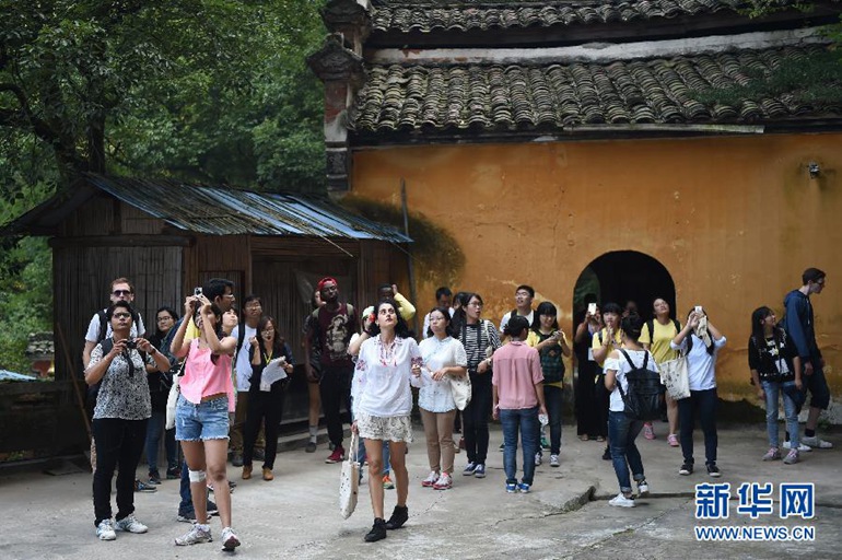  玛丽亚（中）与其他海外学子一同在浙江省金华市汤溪镇寺平村附近的一处寺庙参观（10月21日摄）。