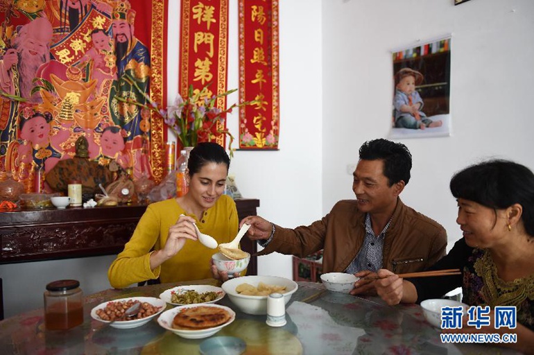  在浙江省金华市汤溪镇寺平村，玛丽亚（左）品尝村民制作的水饺（10月21日摄）。