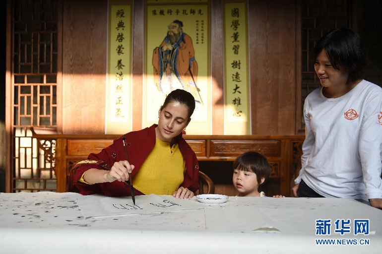 在浙江省金华市汤溪镇寺平村，玛丽亚用毛笔书写自己的中文名“丽丽”（10月21日摄）。