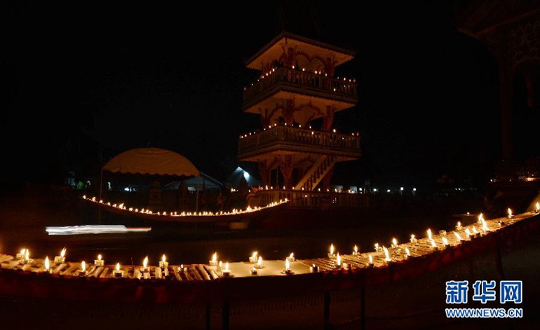  这是10月27日在老挝首都万象拍摄的被烛光点亮的农塔寺。新华社发（刘艾伦摄）