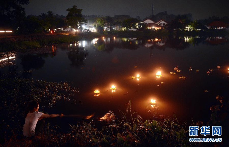 10月27日，在老挝首都万象，当地居民将水灯放入河中。新华社发（刘艾伦摄）