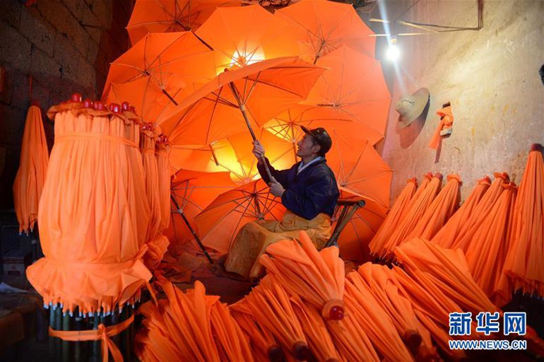 12月3日，在泾县昌桥乡孤峰村国民油布伞厂，工人在检验油伞。新华社记者 刘军喜摄