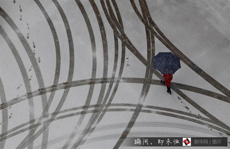 雪中行 11月24日，一名行人在山东省临沂市郯城县街头冒雪出行。当日，山东多地迎明显降雪天气。 新华社发（张春雷 摄）