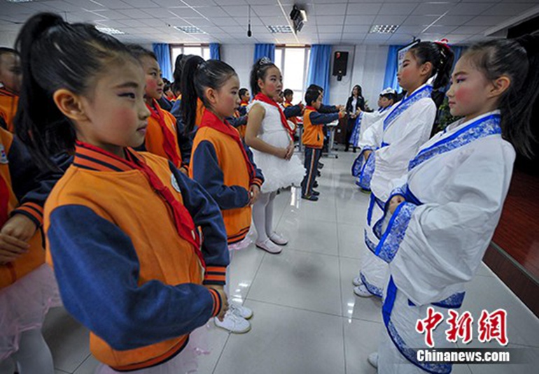 身着汉服的学生向同学们传授传统礼仪。 刘新　摄