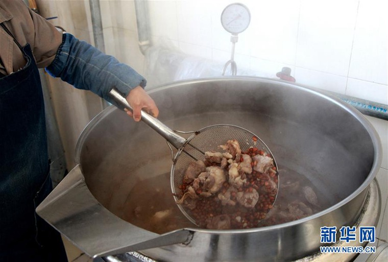 1月14日，在河北石家庄栾城区味道府酒厂，工人将制酒用的羊肉捞出。 新华社发（刘玉和 摄）