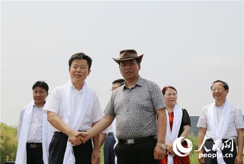 黄河口生态旅游区管委会主任宋家境和玉树州旅游局长阿夏永红握手